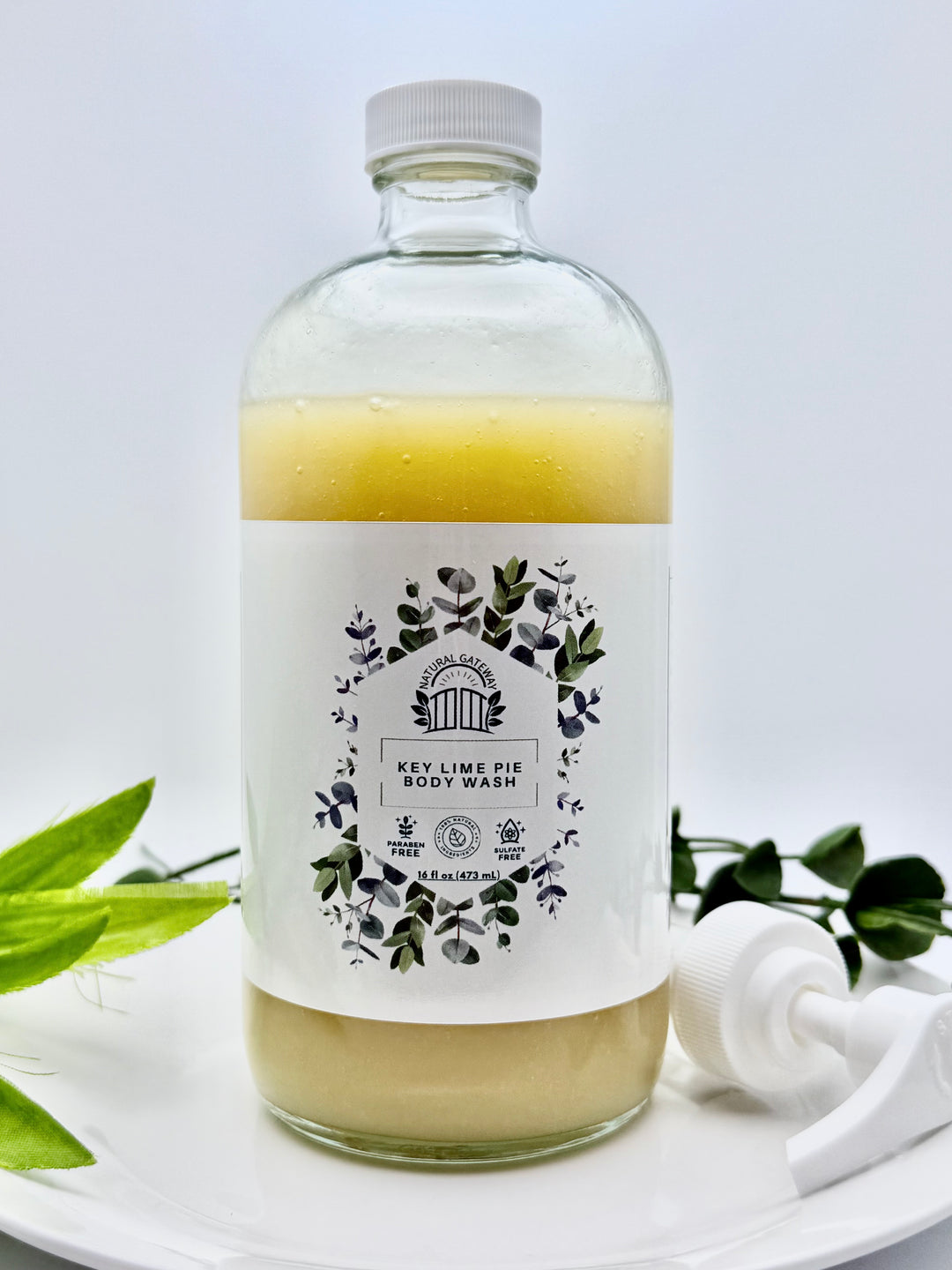 Glass Bottle of Key Lime Pie body wash with a label and white pump